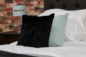 a black pillow sitting on top of a bed at Lawnswood Place in Manchester