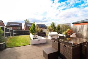 a backyard with a patio with a lawn at Lawnswood Place in Manchester