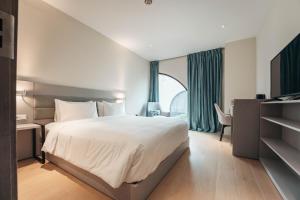 a hotel room with a bed and a large window at Elements Hotel & Shops Curaçao in Willemstad