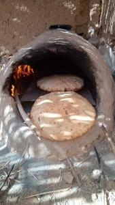 Dos pizzas están cocinando en un horno de piedra en Cafe Restaurant Etto, en Khamliya