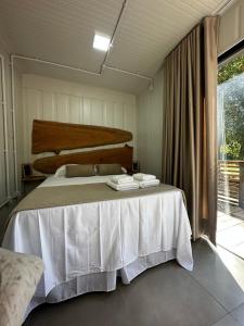 1 dormitorio con 1 cama con 2 toallas en Studios em Contêiner no Bosque, en Itapira