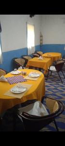 una habitación con varias mesas con manteles amarillos en Cafe Restaurant Etto, en Khamliya