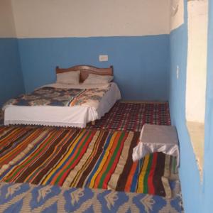 1 dormitorio con 1 cama con pared azul en Cafe Restaurant Etto, en Khamliya