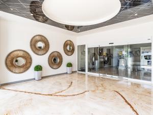 シウダー・フアレスにあるHotel Mesaluna Short & Long Stayの大理石フロアの広い客室で、鏡が備わります。