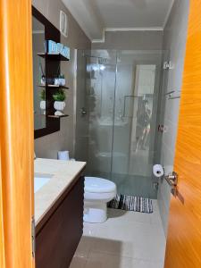a bathroom with a toilet and a glass shower at Acogedor apartamento de playa en Casamar para 4 in San Carlos