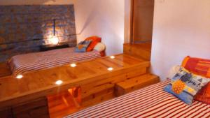a bedroom with two beds and a wooden bed frame at Chez Suzon in Auzon