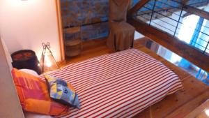 łóżko z czerwonym i białym kocem w pokoju w obiekcie Chez Suzon w mieście Auzon