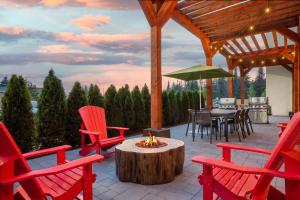 a patio with red chairs and a table with a fire pit at Home2 Suites By Hilton Huntsville in Huntsville