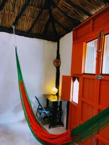 a hammock is hanging in a room with a table at Casa Maya 3 Culturas - Alberca - Wifi Starlink - Tour Sostenibilidad in Izamal