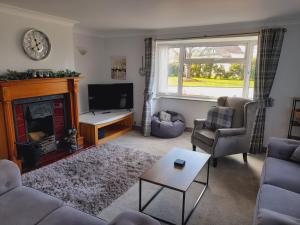 Una sala de estar con chimenea y televisión. en 3 Brookside House, en Pickering