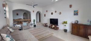 een woonkamer met een bank en een flatscreen-tv bij Sea Pearl in Ras Sedr