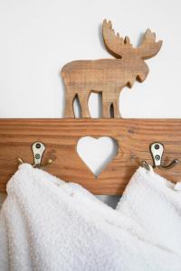 a wooden sign with a deer and a heart at Apartment Pössnecker in Selva di Val Gardena