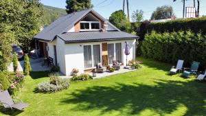 a small white house with a yard at Apartamenty Jagodzianka - Jacuzzi, Sauna, Hot-bania, Tężnia in Ustrzyki Dolne