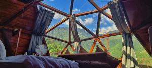 a room with a large window with a view of the mountains at Starlit Dome Mcleodganj in Dharamshala