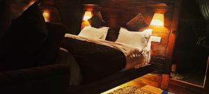 Schlafzimmer mit einem Bett mit einem Kopfteil aus Holz in der Unterkunft Starlit Dome Mcleodganj in Dharamshala
