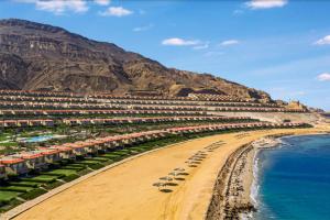 uma praia com um monte de edifícios e o oceano em Telal Ground Floor 2 bedroms em Ain Sokhna