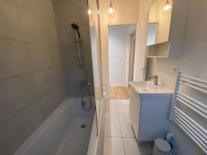 a bathroom with a shower and a tub and a sink at La Mansarde LCD Pontoise in Pontoise