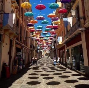 uma linha de guarda-chuvas pendurada sobre uma rua em Casa vacanze sa Cresiedda em Iglesias
