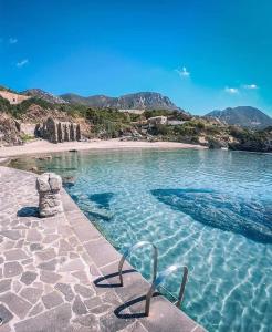 una silla sentada en el agua junto a una playa en Casa vacanze sa Cresiedda, en Iglesias