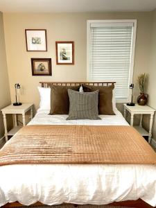 een slaapkamer met een groot bed en 2 tafels bij Cozy Cottage Convenience in Penfield
