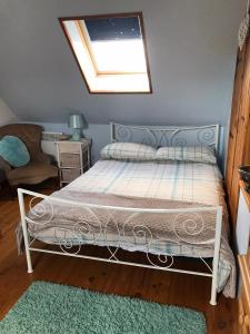 a bedroom with a bed and a skylight at Cottage Les Glycines in Javron-Les-Chapelles
