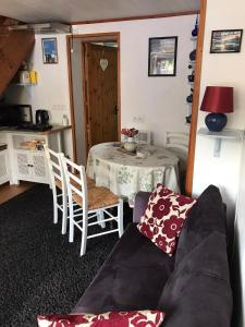 un soggiorno con un tavolo e un divano di Cottage Les Glycines a Javron-Les-Chapelles