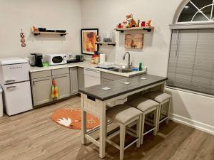 a kitchen with a sink and a counter with stools at Foxs Den Hot Tub Bbq Queen Bed Sleeps 2 in Ahwahnee +7 photos