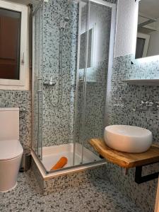 uma casa de banho com um chuveiro, um lavatório e um WC. em Haus Atlantic Leukerbad em Leukerbad