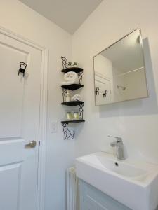 a white bathroom with a sink and a mirror at 2B with parking, 10km to Toronto downtown in Toronto