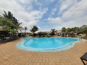 una gran piscina azul en un complejo en Tortuga beach lovely 2 bed apartment and gardens, en Santa Maria