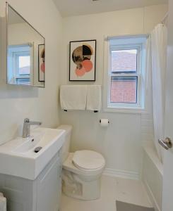 a white bathroom with a sink and a toilet at 2B with parking, 10km to Toronto downtown in Toronto