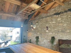 a dining room with a stone wall and a wooden table at Suite 110 in Farra