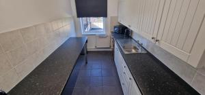 eine kleine Küche mit einer Spüle und einer Theke in der Unterkunft APARTMENT IN CENTRAL BARNSLEY in Barnsley