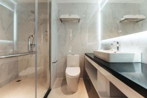 a bathroom with a sink and a toilet and a shower at Elements Hotel & Shops Curaçao in Willemstad