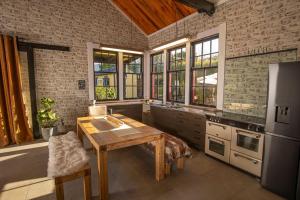 a kitchen with a wooden table and some windows at The Full Factory Experience in Hapuku