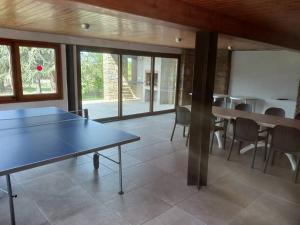 - une table de ping-pong dans une pièce avec des tables et des chaises dans l'établissement Fantástico chalet para familias y grupos, à Sant Juliá de Vilatorta