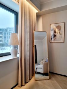 lustro w pokoju z krzesłem i oknem w obiekcie Hilltop Apartments - Kiikri Residence City Centre w Tallinnie