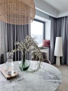 uma sala de estar com uma mesa com um vaso de flores em Hilltop Apartments - Kiikri Residence City Centre em Talin