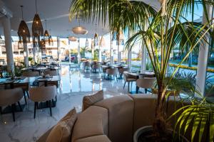a restaurant with tables and chairs and a palm tree at SYRAH Premium B2 - Vistas al Parque by depptö in Punta del Este