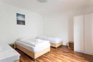 two beds in a room with wooden floors at T&K Apartments - Duisburg - 3 and 4 Room Monteur Apartments in Duisburg