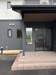 eine Eingangstür eines Gebäudes mit Bürgersteig in der Unterkunft Guesthouse Hatenashi - Vacation STAY 43934v in Hongu