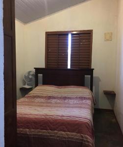een slaapkamer met een bed en een raam met een sprei bij Residencial Recanto do Sabiá in Alto Paraíso de Goiás