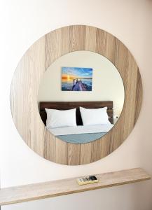 eleftheria's apartment في مدينة خانيا: مرآة دائرية فوق سرير في غرفة