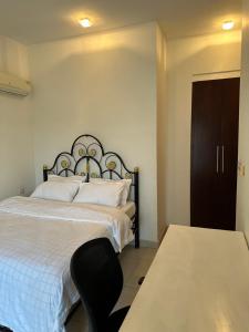 1 dormitorio con 1 cama y 1 silla en The Perfect Cozy Home For You, en Dar es Salaam
