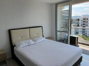 Un dormitorio con una cama grande y una ventana grande. en Disconnect, rest and enjoy., en Ricaurte 40 fotos más