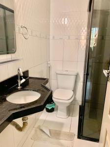 a bathroom with a toilet and a sink and a shower at Apartamento amplo e confortável in Belém +48 photos