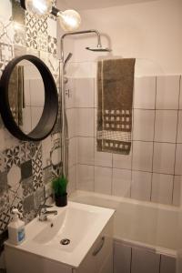 Quiet Studio في بيتشتي: حمام مع حوض ومرآة وحوض استحمام