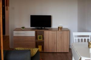 a television on a wooden cabinet in a living room at Quiet Studio in Piteşti