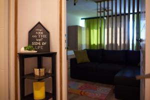 Quiet Studio في بيتشتي: غرفة معيشة مع أريكة زرقاء وعلامة