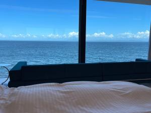 uma cama num quarto com vista para o oceano em Namioto Terrace Suite Villa in AIGA - Vacation STAY 30547v em Sumoto